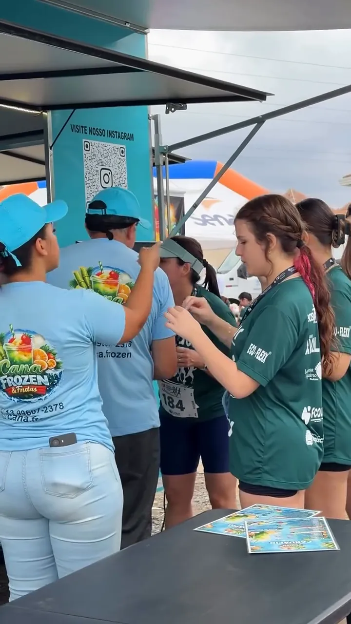 Equipe da Cana Frozen entregando raspadinhas aos corredores no balcão do truck