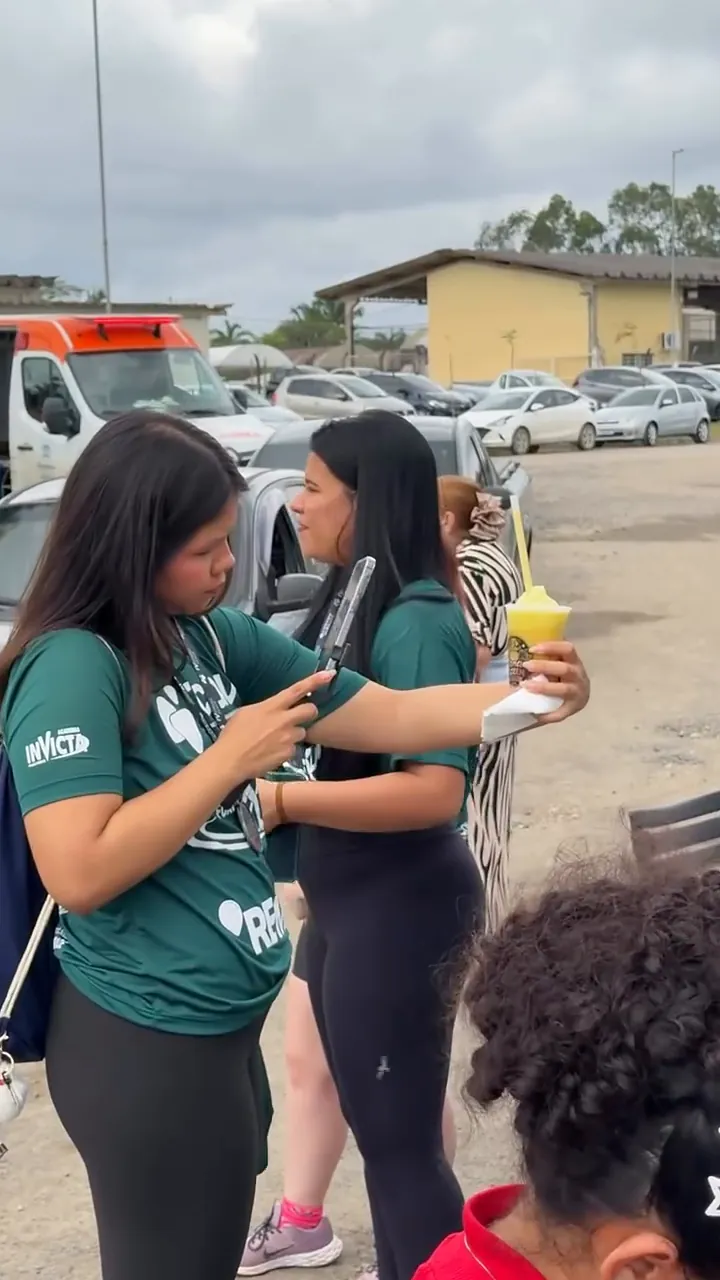 Corredora segurando um copo de raspadinha amarela da Cana Frozen
